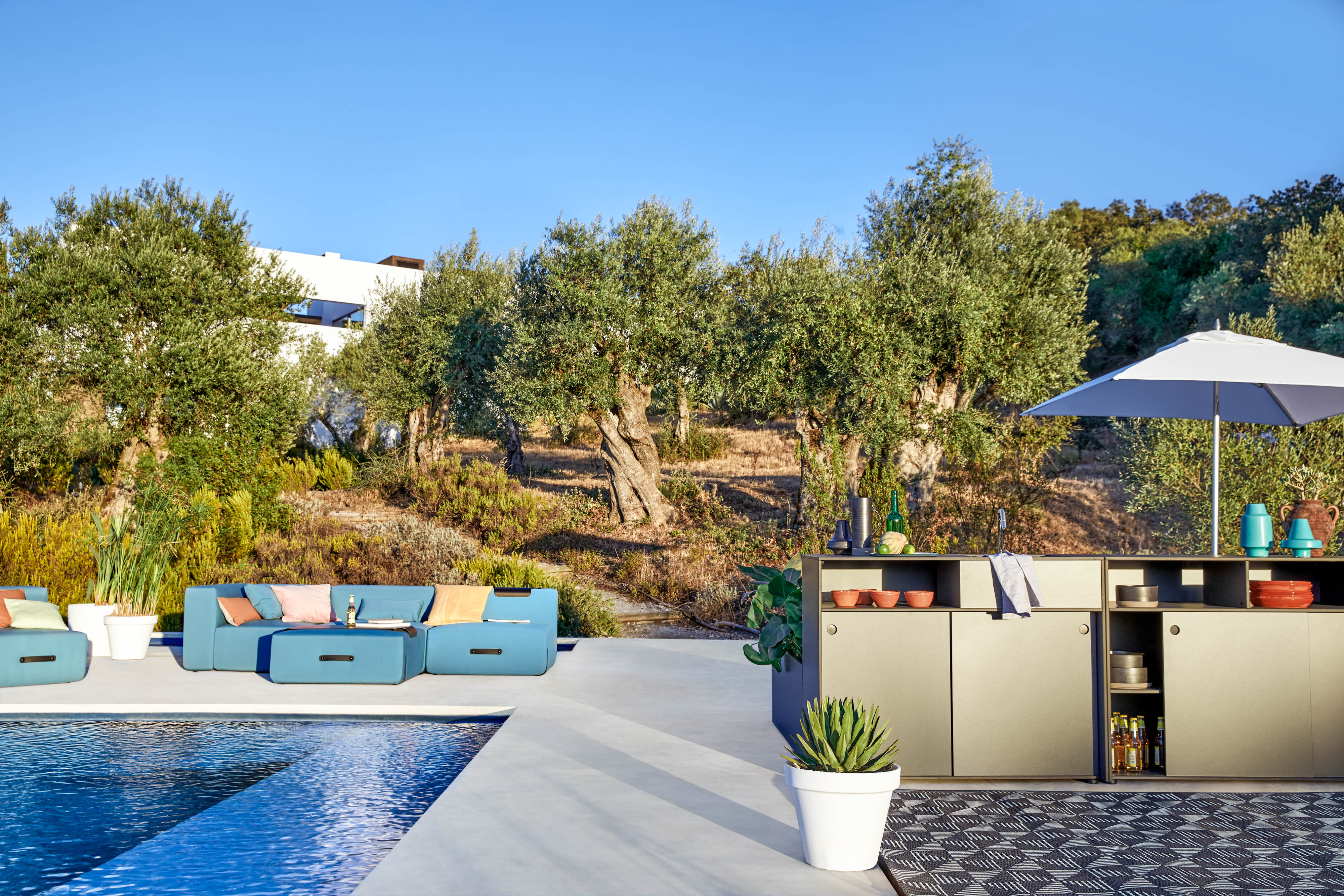 Miami Outdoor Sofa von Conmoto neben Pool und Outdoor-Küche, mediterranes Design für Garten und Terrasse.