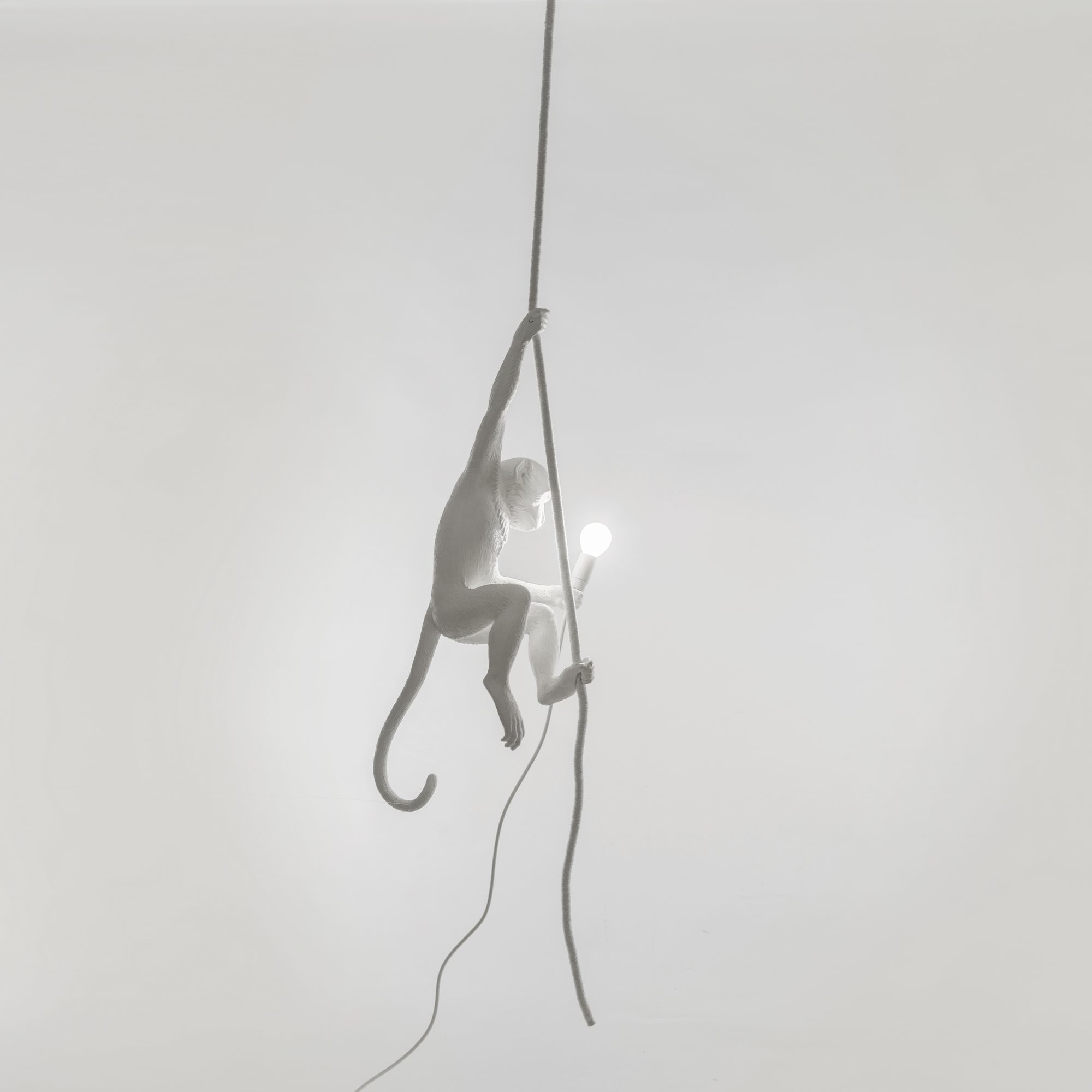 Weiße Monkey Lamp Pendelleuchte von Seletti, ein Affe hält eine Glühbirne an einem Seil.
