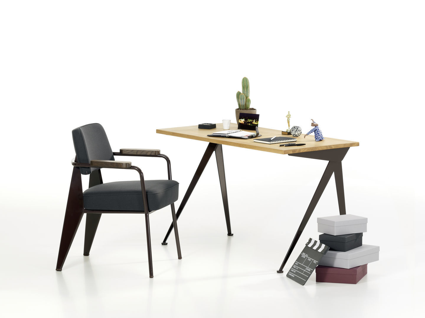Grauer Fauteuil Direction Sessel von Vitra mit Holzarmlehnen vor einem Schreibtisch. Bürostuhl für stilvolles Arbeiten.