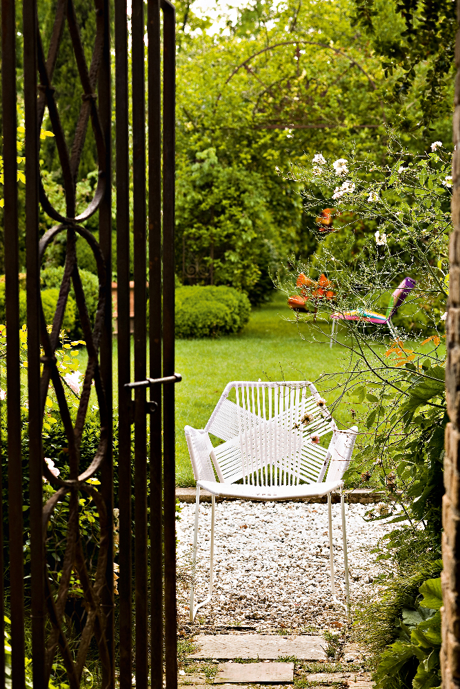 Weißer Tropicalia Armchair Outdoor Armlehnenstuhl von Moroso im Garten, gesehen durch ein offenes Gartentor.