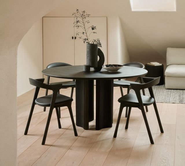 Schwarzer runder Esstisch mit vier Stühlen im modernen Design für Esszimmer oder Küche.