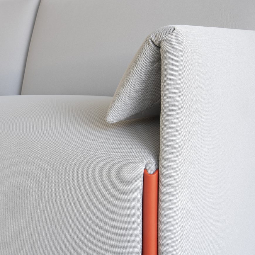 Detailaufnahme: Costume Modulsofa mit Armlehne links und orangefarbenem Detail. Modernes Sofa für Wohnzimmer.