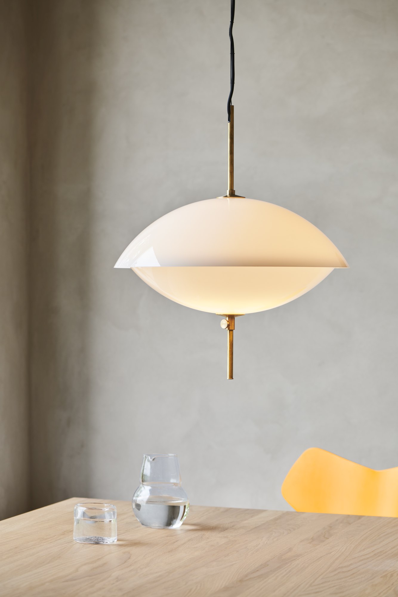 Nahaufnahme der Clam Pendelleuchte von Fritz Hansen, weiße Hängelampe mit Messingdetails.