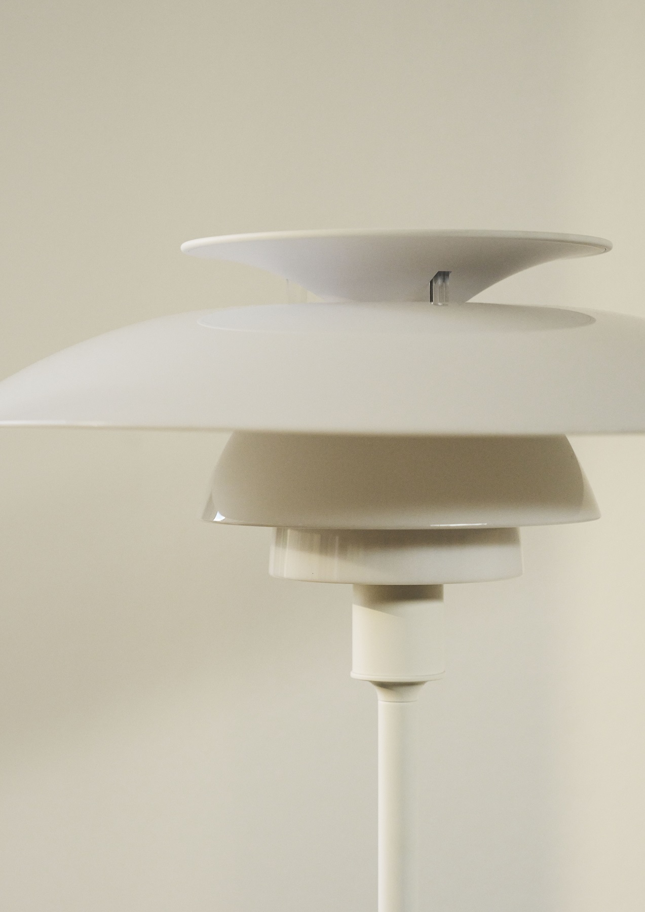Nahaufnahme der weißen PH 80 Tischleuchte von Louis Poulsen mit ikonischem Schirmdesign.