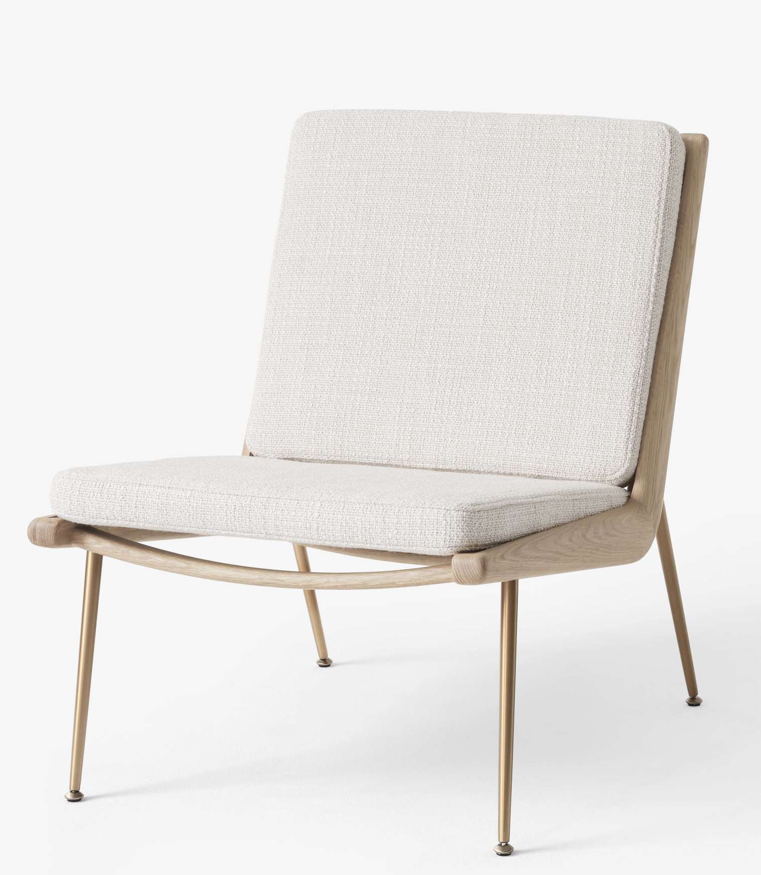 AndTradition Boomerang Lounge Chair HM1 Sessel mit hellem Stoffbezug und filigranem Holzgestell auf goldenen Füßen.
