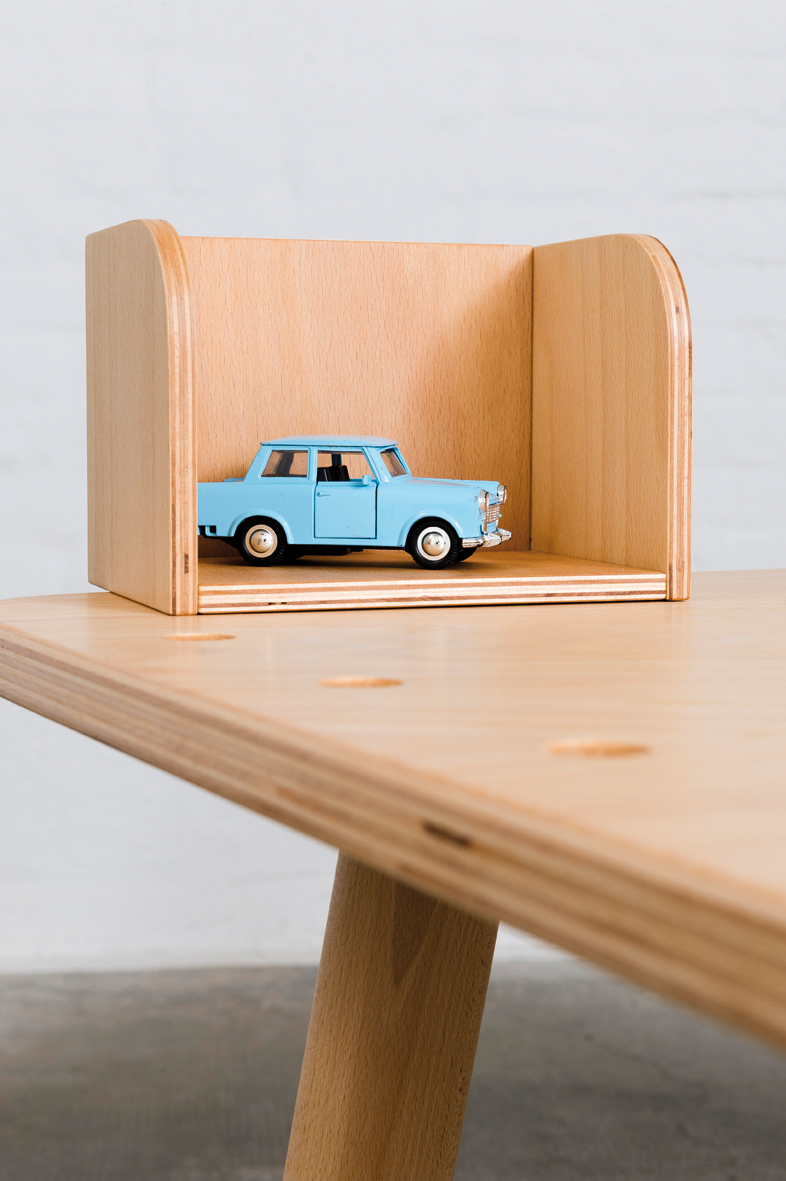 Growing Table aus Buche: Detailansicht mit Spielzeugauto im Regal des Kindertisches.