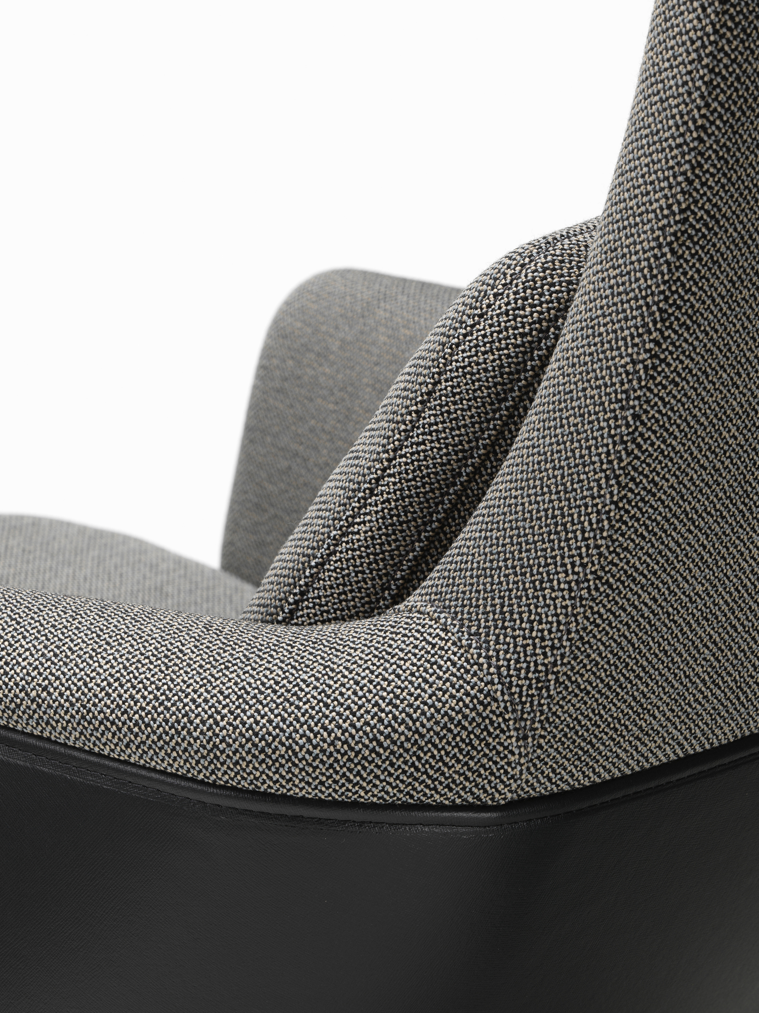 Detailaufnahme des Vitra Grand Relax Sessels mit grau meliertem Stoffbezug und schwarzem Lederakzent.