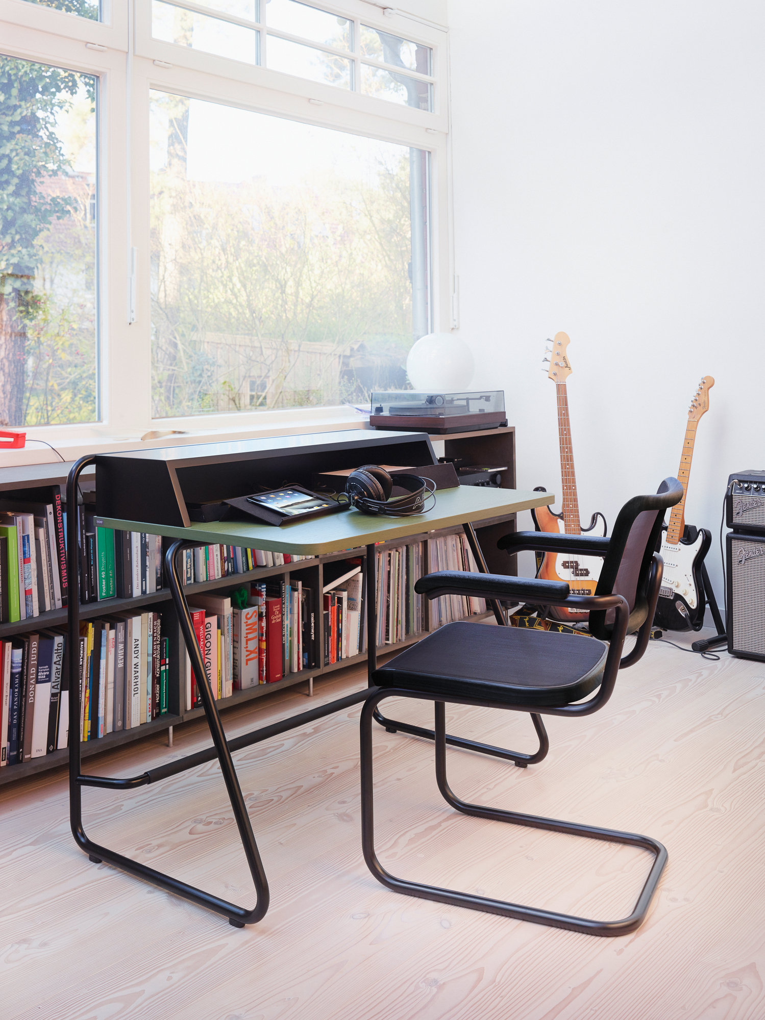 Thonet S 1200 Sekretär mit Regal, Schreibtischstuhl und Musikinstrumenten vor Fenster für modernes Wohnen.