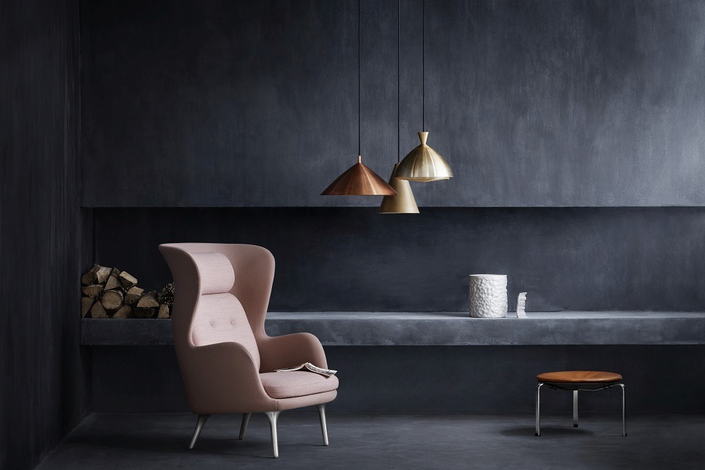 Interieur mit Sessel, Pendelleuchten und Fritz Hansen PK33 Hocker mit Lederbezug und Stahlgestell.