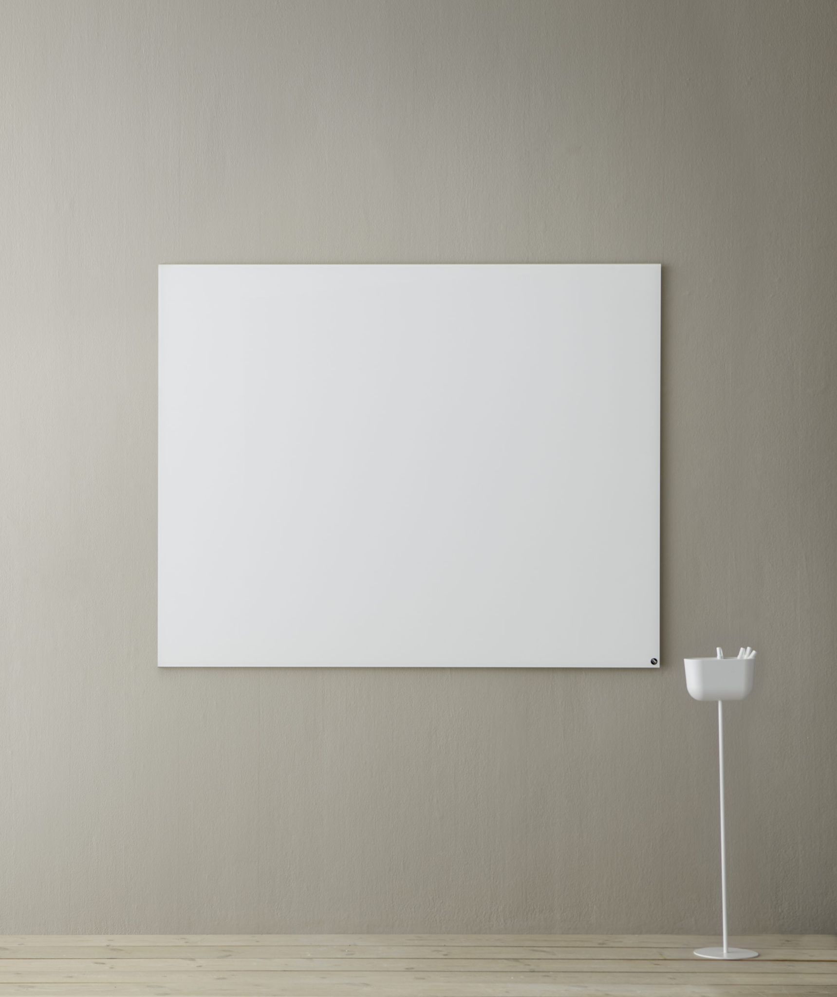 Weiße Chat Board Elements magnetische Glastafel an einer Wand, daneben ein Stifthalter.