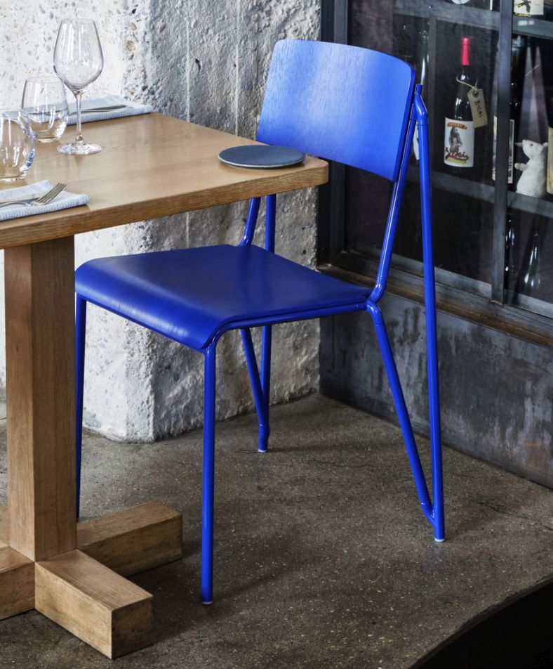 Blauer Hay Stuhl der Petit Standard Serie am Holztisch in modernem Ambiente.