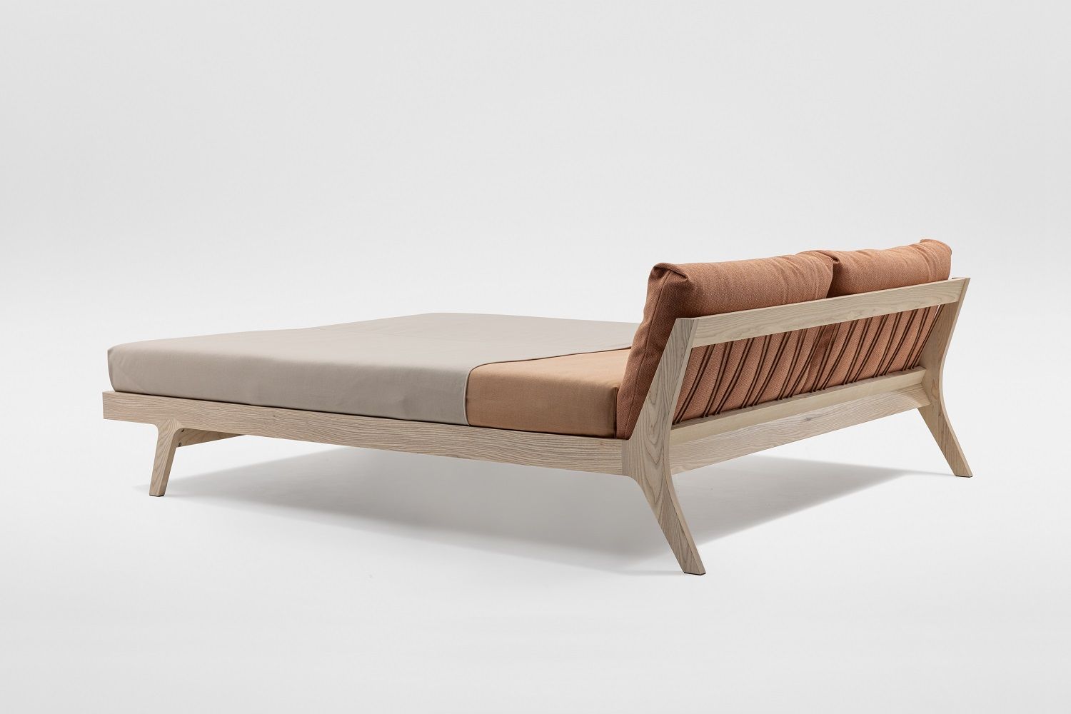 Mellow Bett aus Massivholz: Modernes Holzbett mit gepolstertem Kopfteil in Braun.
