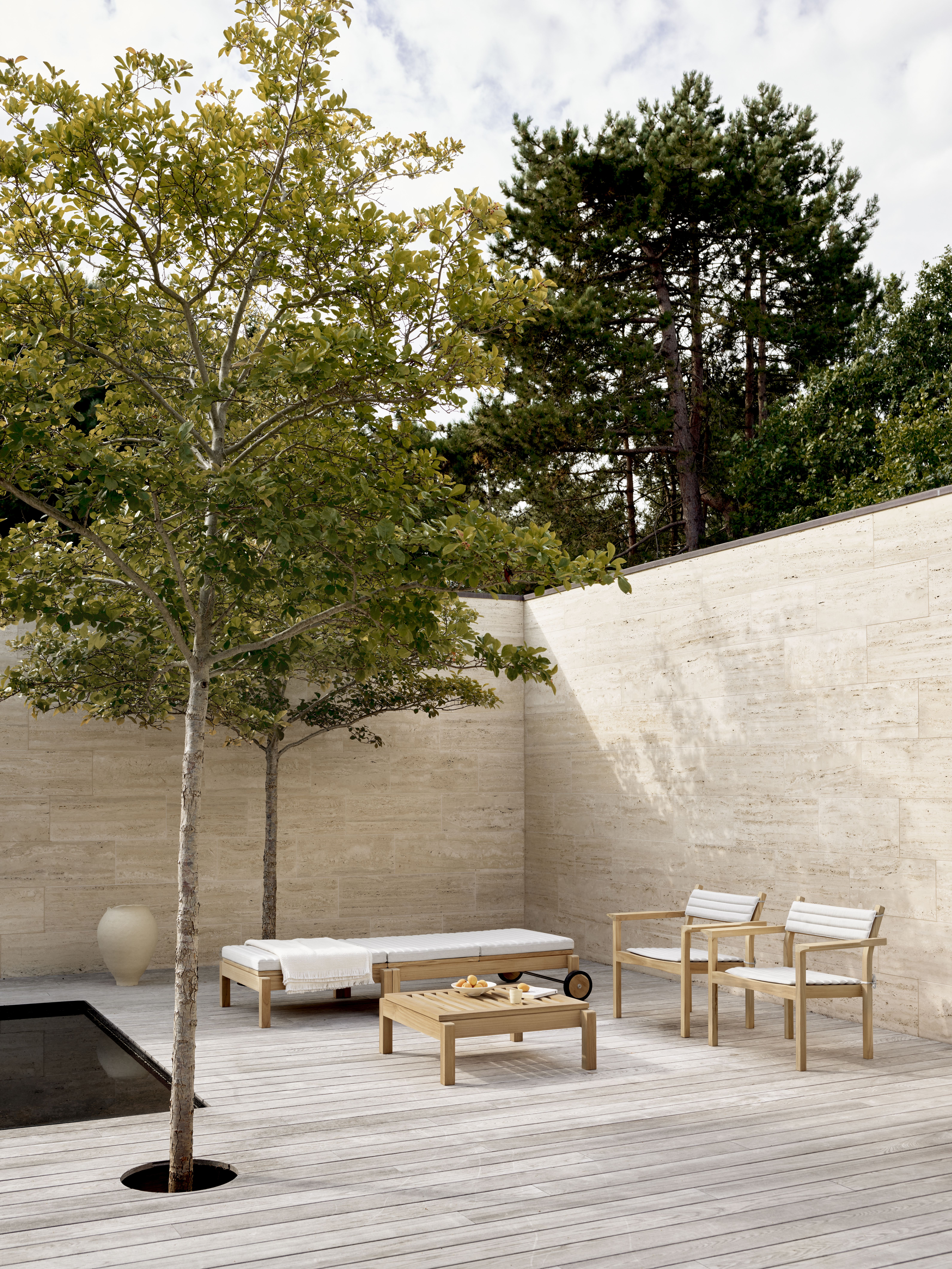 AH604 Gartenliege von Carl Hansen & Søn aus Teakholz mit passenden Gartenmöbeln im Außenbereich.