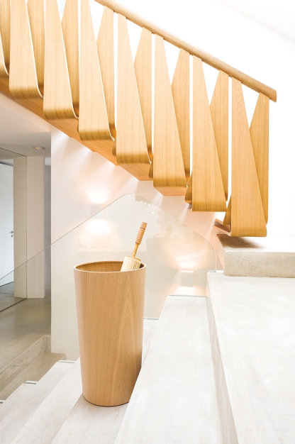 Schönbuch Schirmständer 0514 aus hellem Holz auf einer Treppe mit Schirm. Moderner Schirmhalter.