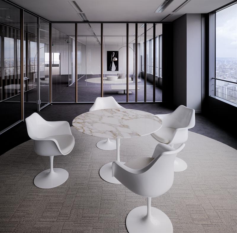 Innenaufnahme: Knoll International Tulpen Armlehnenstühle in Weiß um einen runden Marmortisch in einem modernen Büro.