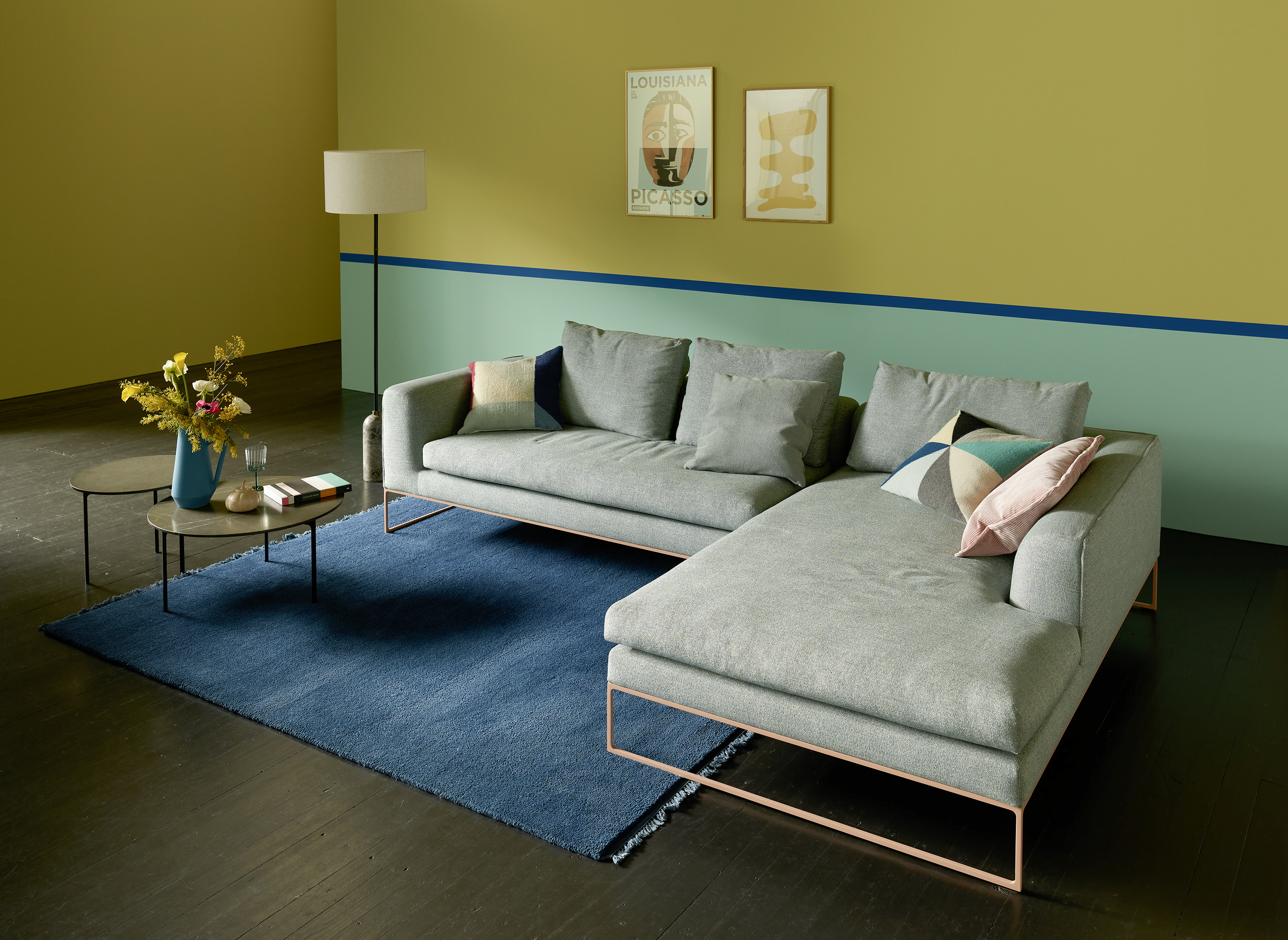 Modernes Mell Lounge Sofa von Cor in grau mit Kissen und Teppich im Wohnzimmer.
