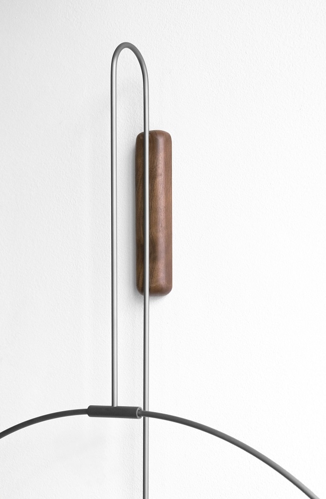 Detailaufnahme der Daro Clock Wanduhr von nomon mit Holz- und Metallelementen an einer weißen Wand.