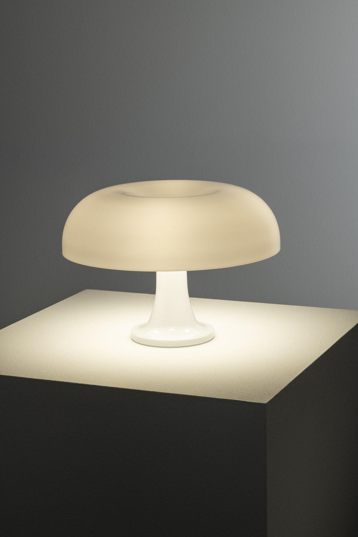 Weiße Nessino Tischleuchte von Artemide mit pilzförmigem Lampenschirm spendet warmes Licht. Designklassiker für Wohnzimmer und Schlafzimmer.
