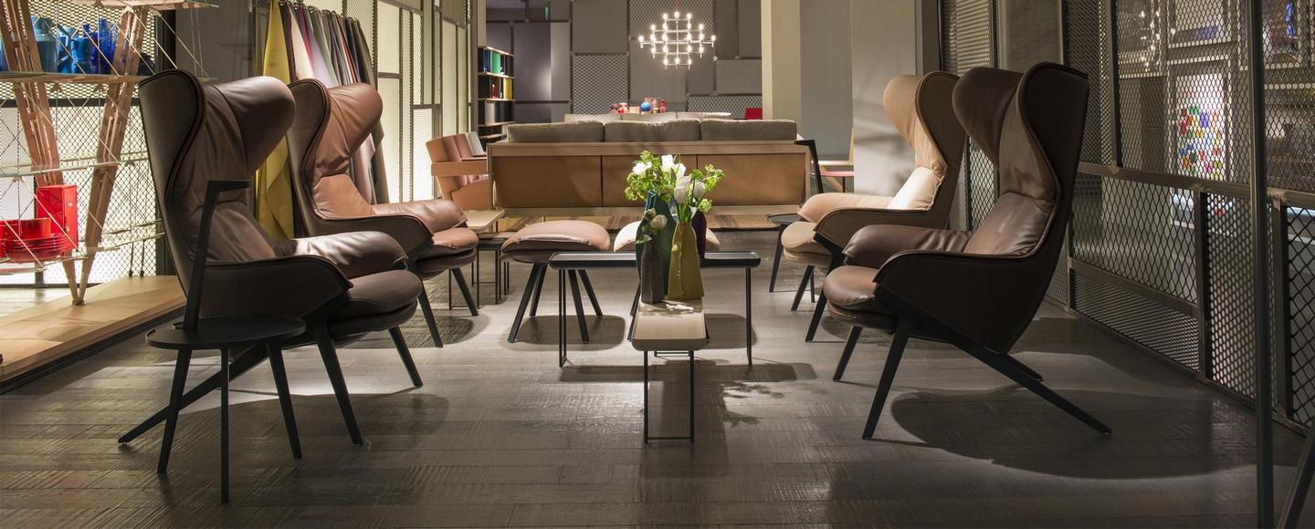 Brauner Ledersessel im Raum, möglicherweise ein Cassina 395 P22 Design Sessel.