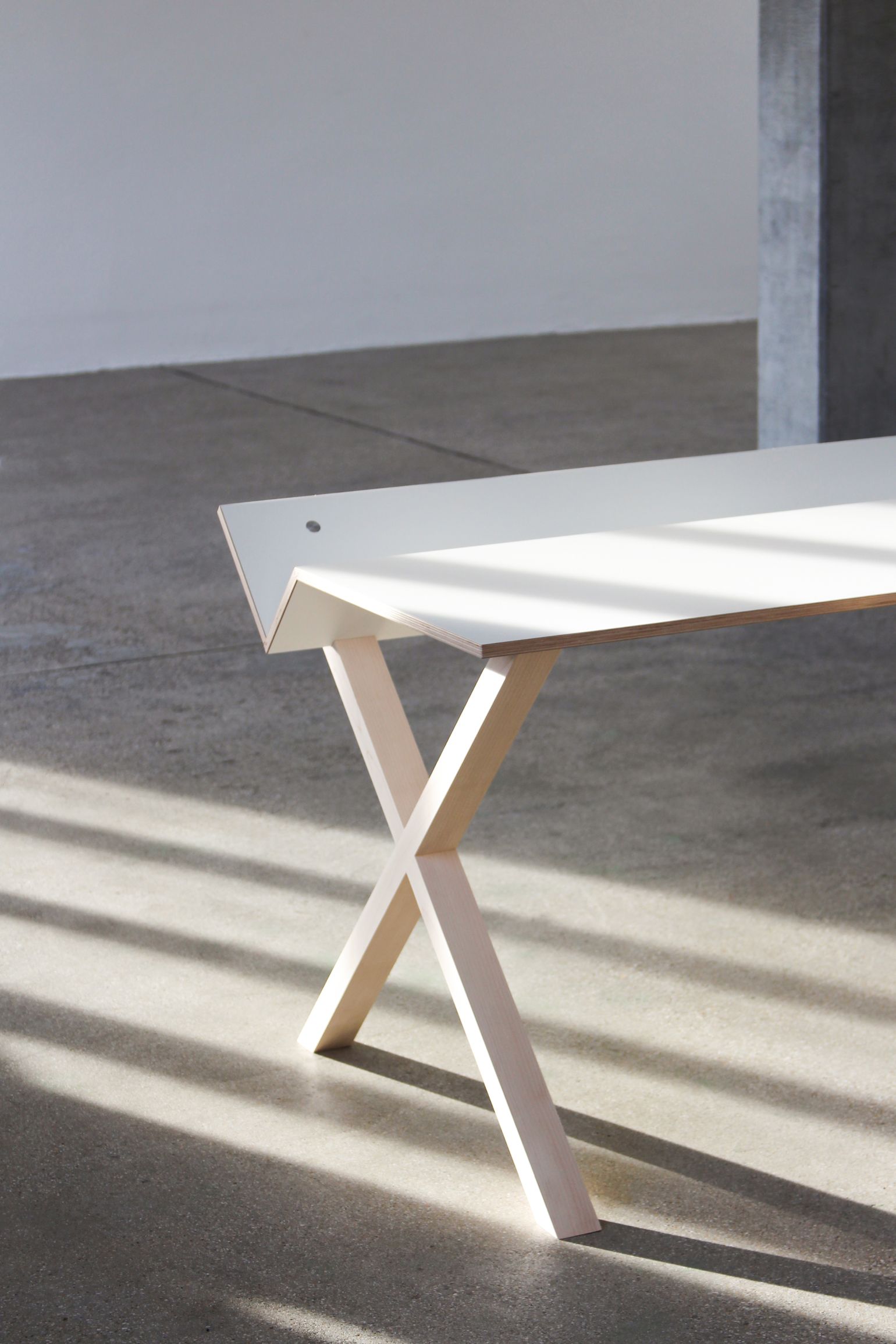 Kant Schreibtisch von Nils Holger Moormann, weiß, mit ungewöhnlichem X-förmigen Holzgestell im minimalistischen Design.