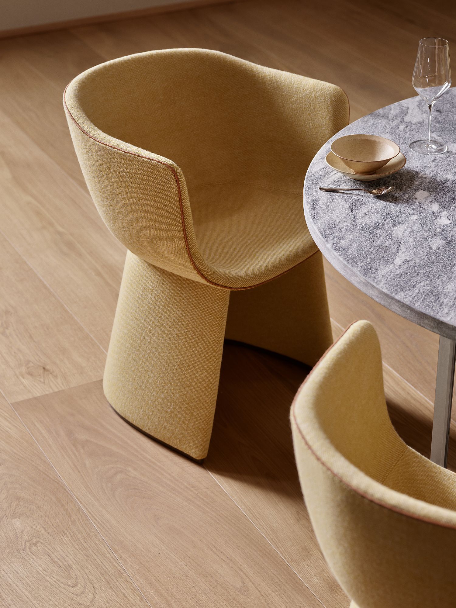 Gelber Monolit Stuhl von Fritz Hansen am Esstisch, moderner Loungesessel mit Stoffbezug.