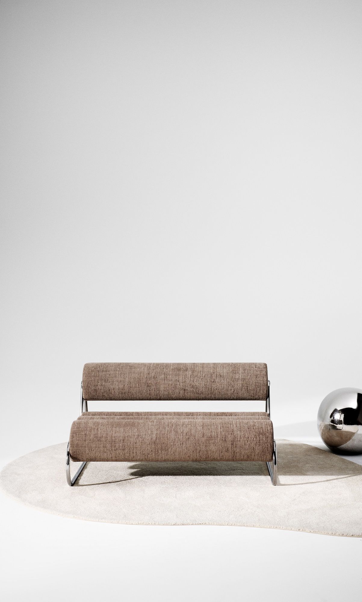 Fave Sofa 2-Sitzer von Norr11 mit schwarzem Gestell und braunem Stoffbezug auf einem runden Teppich.
