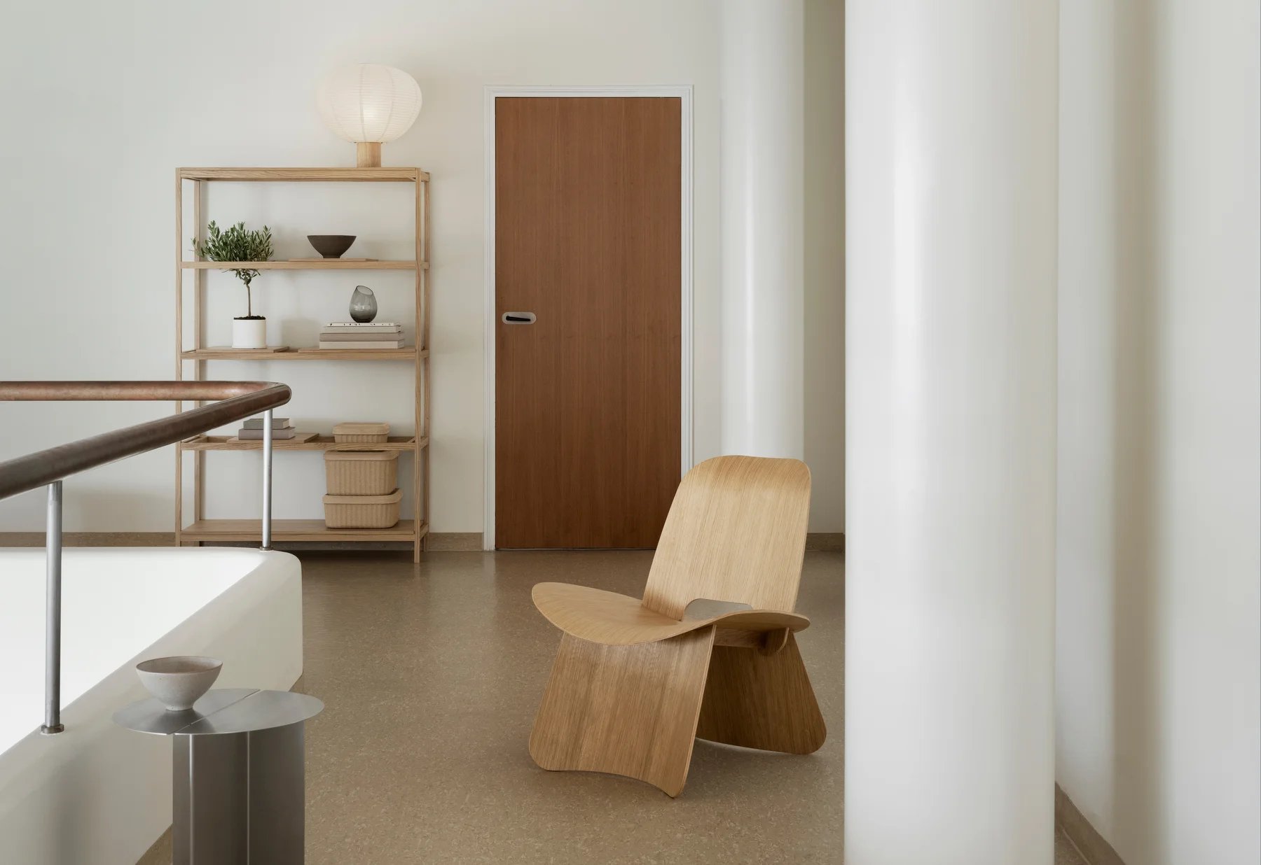 Helle minimalistische Inneneinrichtung mit Blomus Kami Reispapier Tischleuchte auf einem Holzregal, neben einem Holztür.