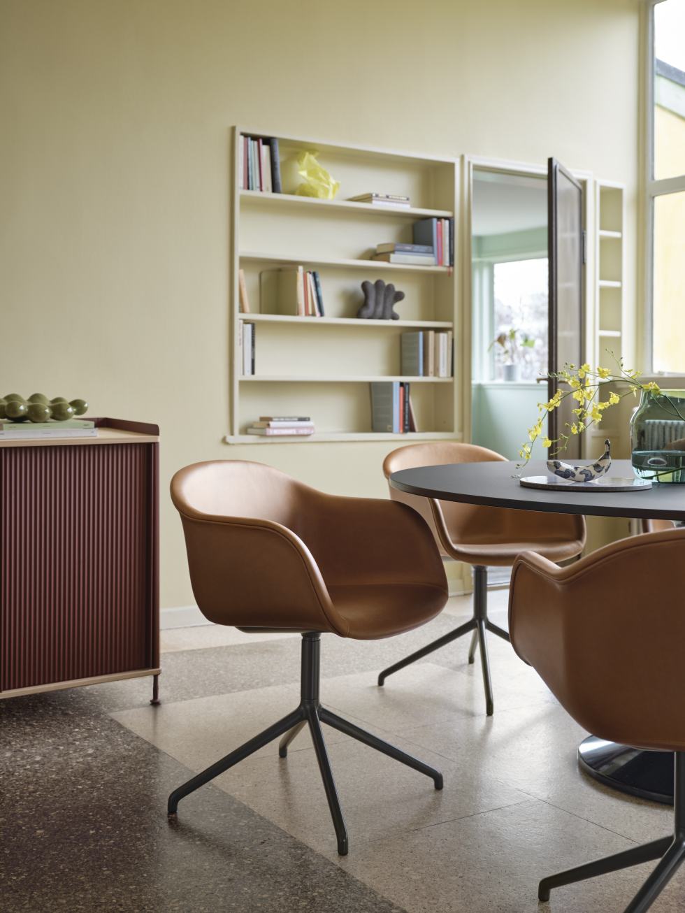 Esszimmer mit Muuto Enfold Sideboard und braunen Lederstühlen um einen runden Tisch.