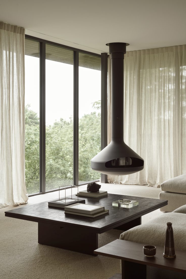 Grooves Coffee Table von Ethnicraft im modernen Wohnzimmer mit Kamin und Fensterfront.