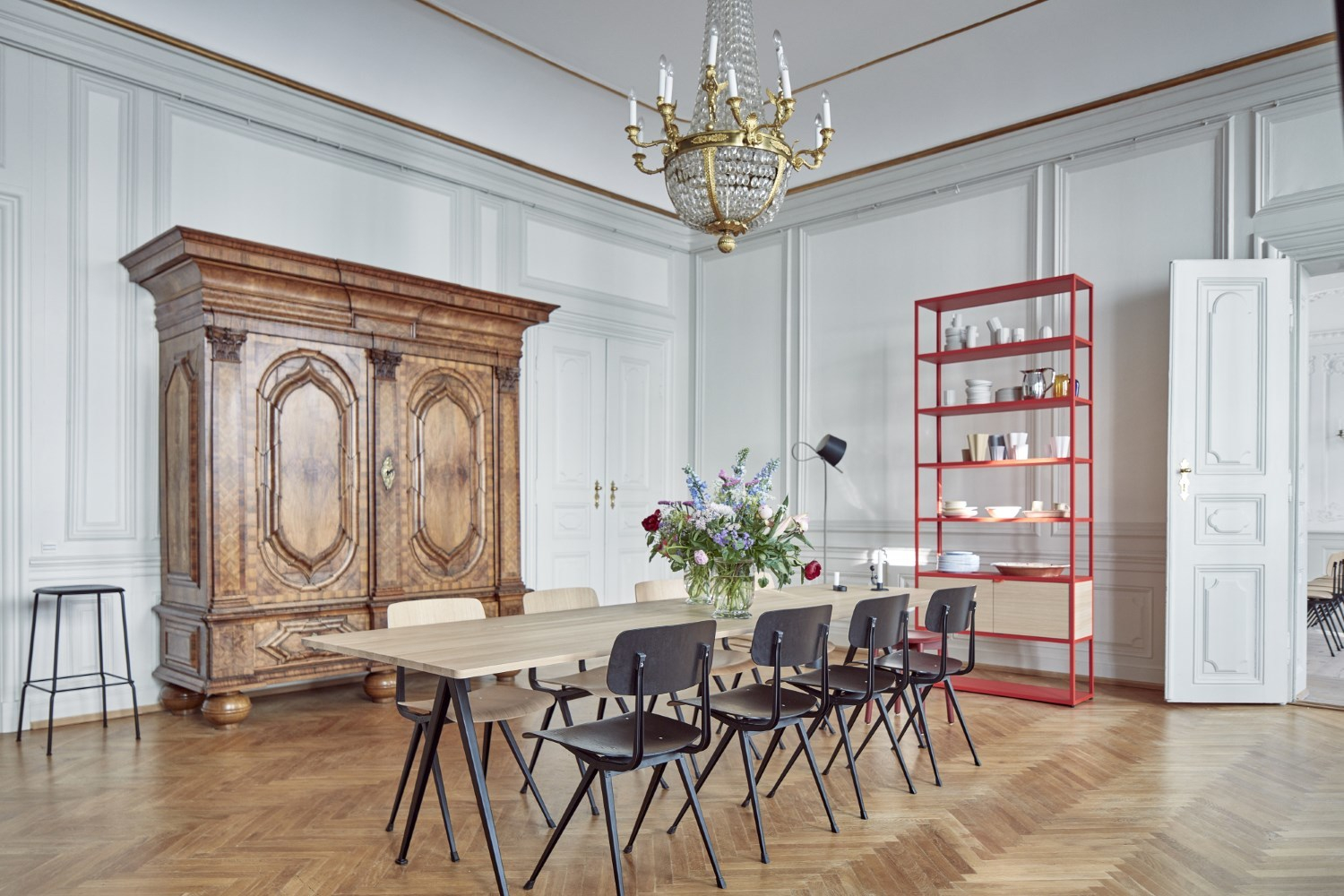 Innenaufnahme eines Esszimmers mit langem Holztisch und schwarzen Result Chair Stühlen von Hay.