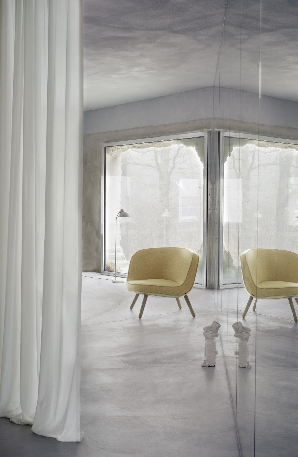 Gelber Fritz Hansen Sessel Via57 in modernem Interieur mit großem Fenster und minimalistischer Dekoration.