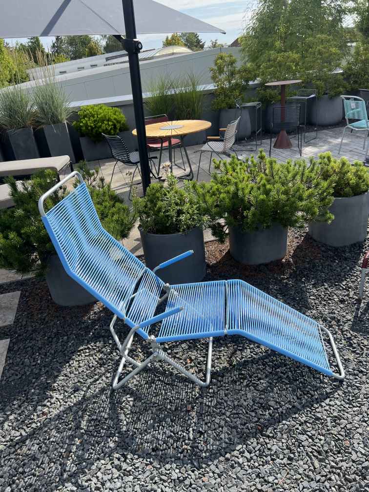 Altorfer Liegestuhl Outdoor hellblau auf Kiesboden, moderne Gartenliege mit silbernem Gestell für entspannte Stunden.
