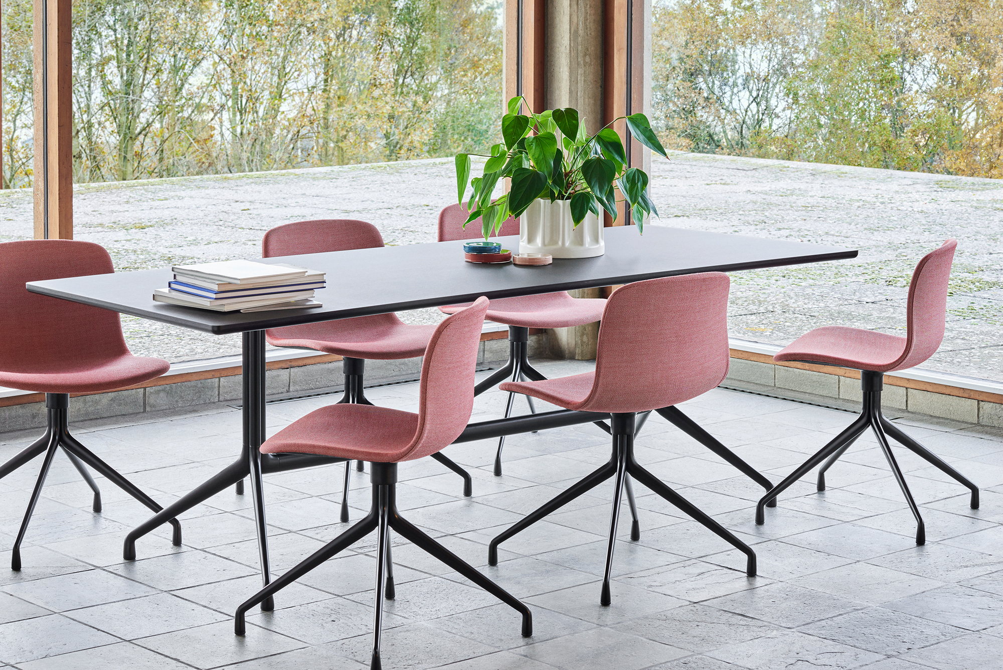 Esstisch mit sechs About a Chair AAC 11 Stühlen mit roter Vollpolsterung und schwarzem Vierfußgestell.