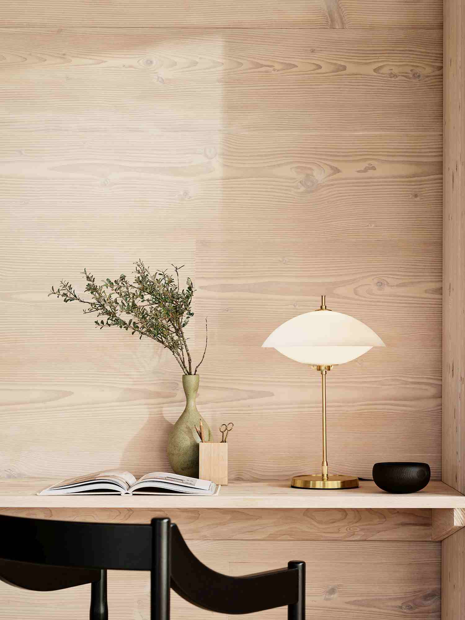 Nahaufnahme der Fritz Hansen Clam Tischleuchte mit Messingfuß und sanftem Licht.
