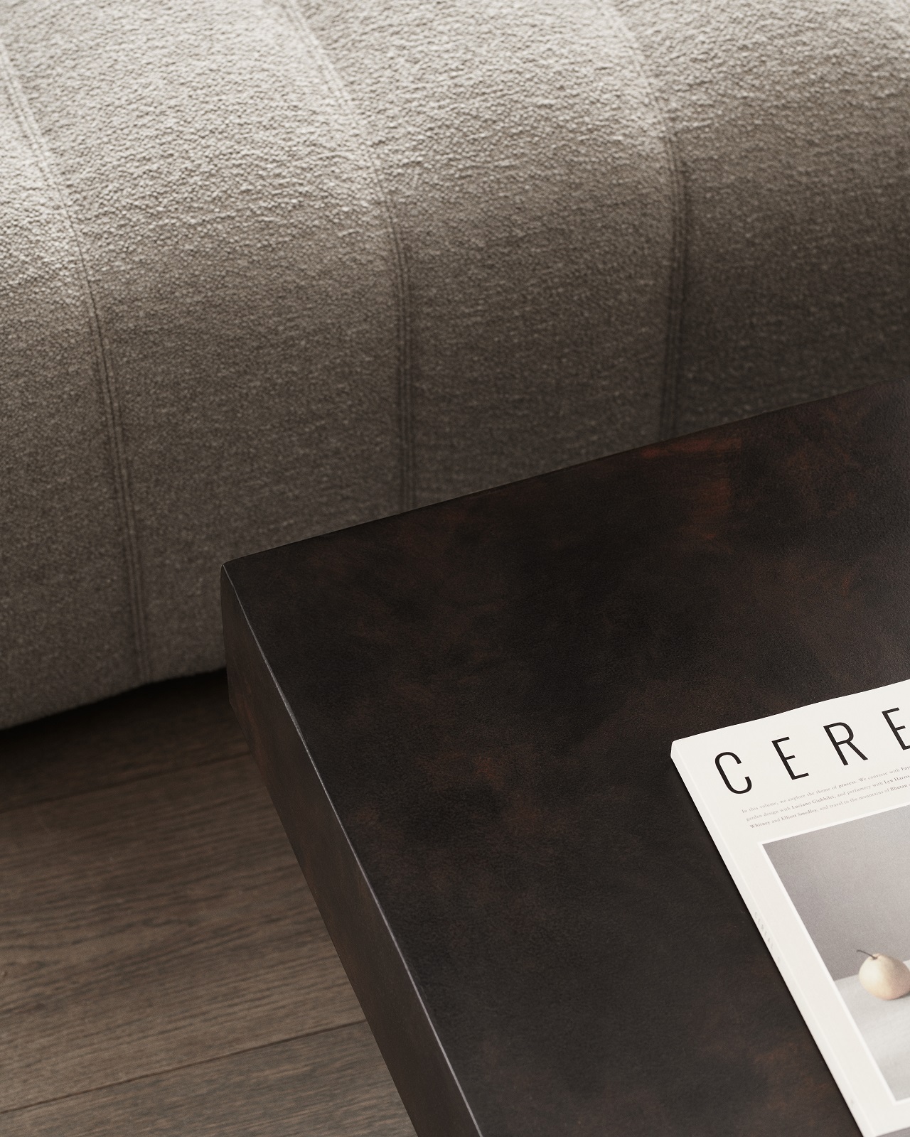 Detailaufnahme des Gear Square Couchtischs von Norr11 in dunklem Holz neben einem grauen Sofa.