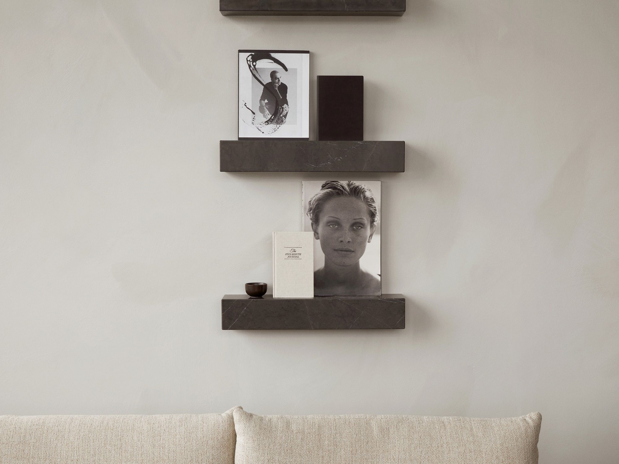 Nahaufnahme von drei grauen Audo Copenhagen Plinth Shelf Regalen an einer Wand mit Deko.