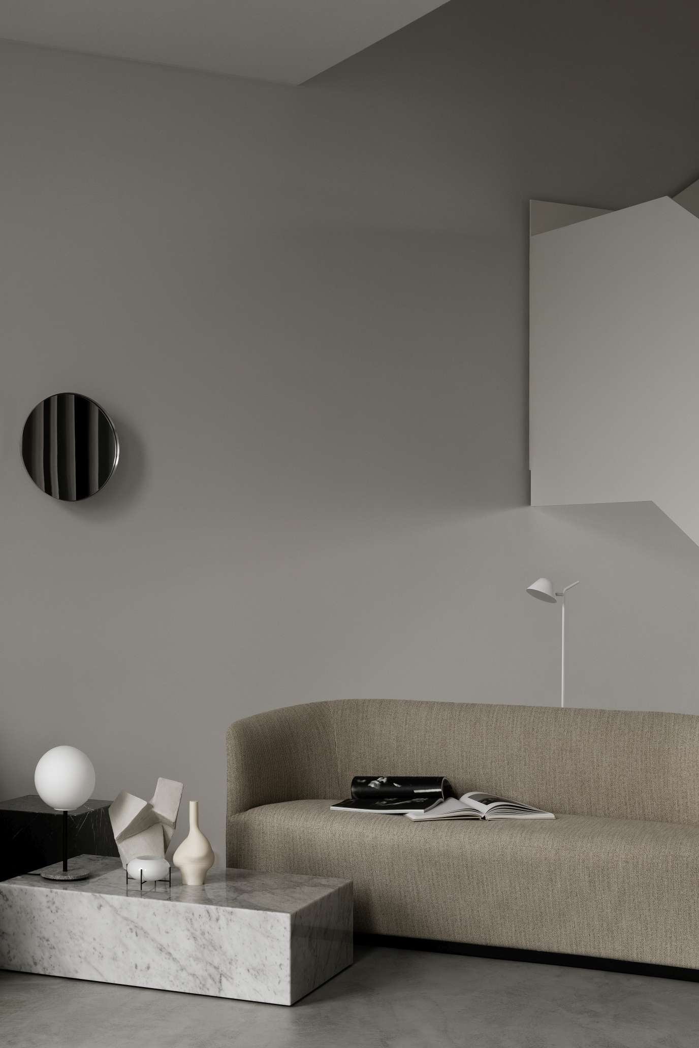 Audo Copenhagen Plinth Tisch aus Marmor im Wohnzimmer mit Sofa und Dekoration.