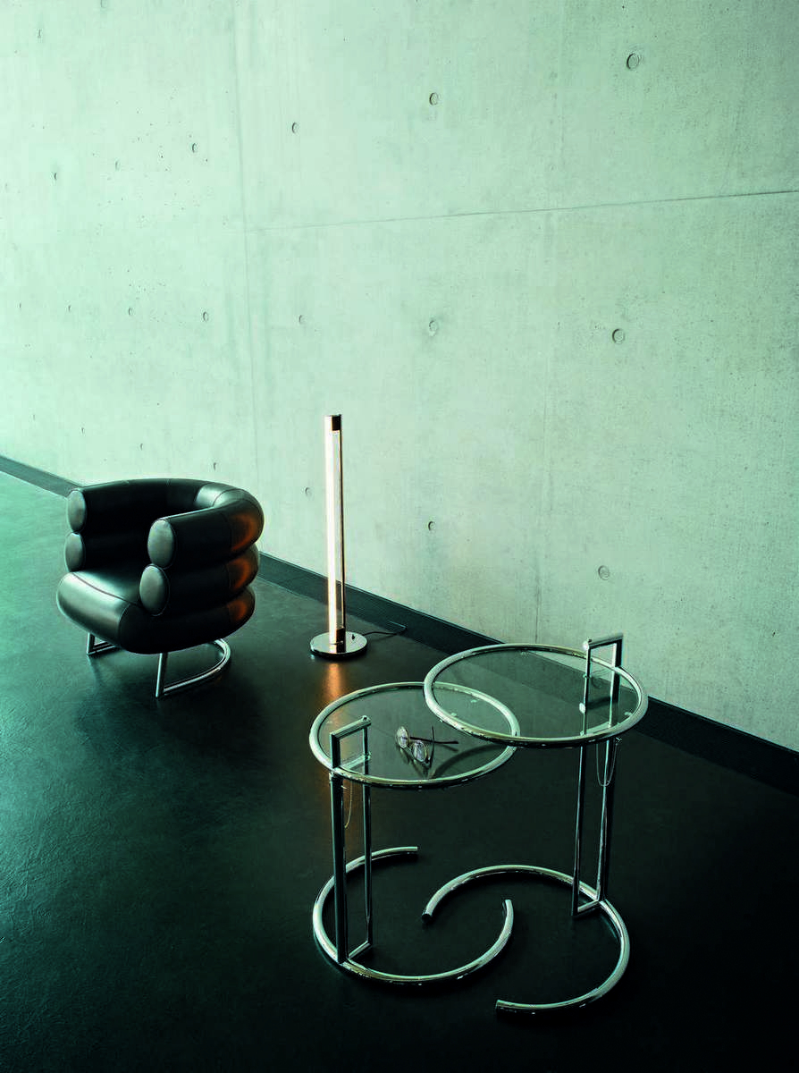 ClassiCon Tube Light Stehleuchte neben Sessel und Beistelltisch, modernes Wohnambiente mit Designermöbeln.