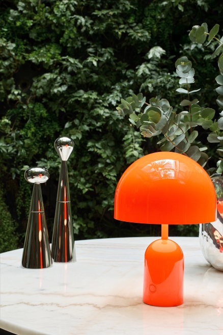 Orangefarbene Bell Portable LED Tischleuchte von Tom Dixon auf einem Tisch.