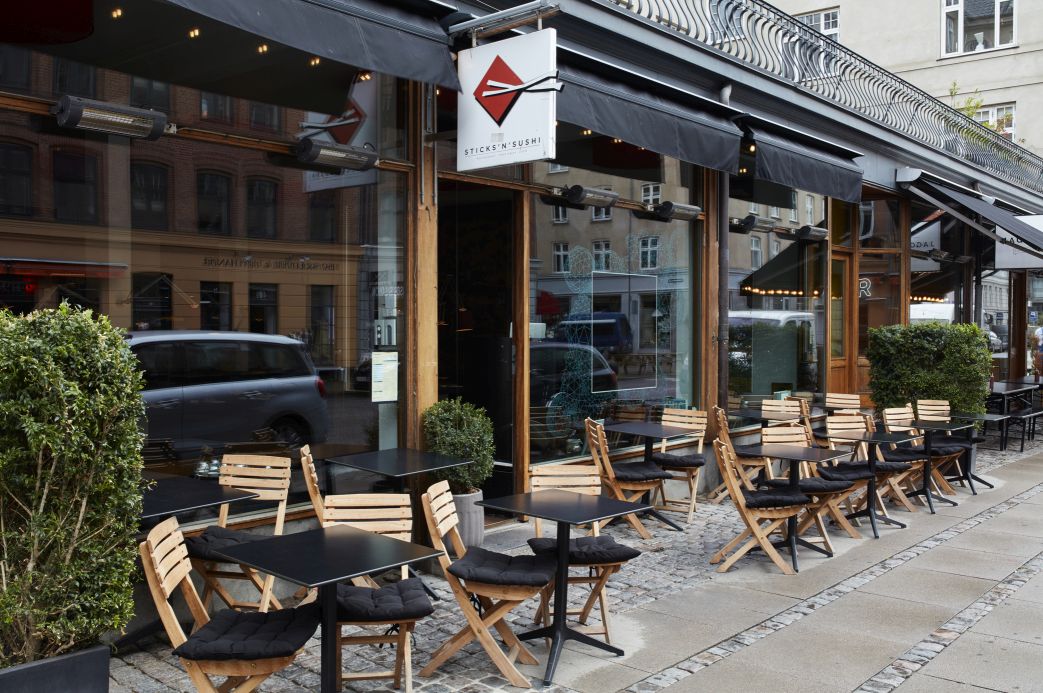 Außenbereich eines Restaurants mit Vendia Klappstühlen von Skagerak by Fritz Hansen und schwarzen Tischen.