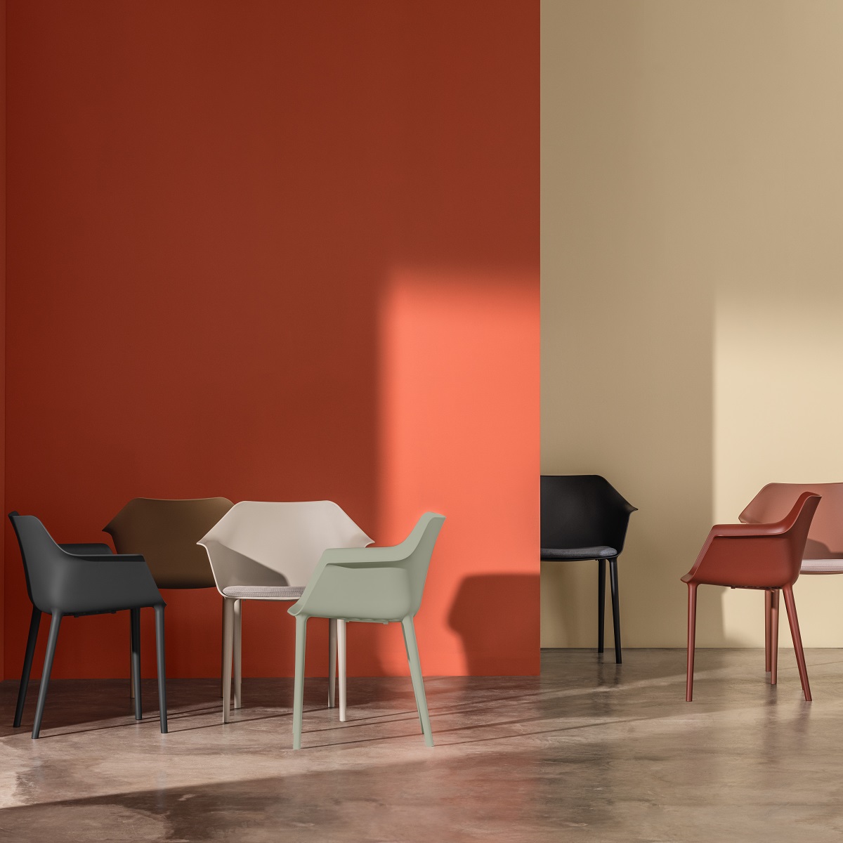 Gala Pure Eco Sessel von Andreu World in verschiedenen Farben vor farbigen Wänden.