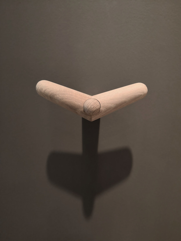 Detailaufnahme des Tail Wing Haken von Woud, ein moderner Wandhaken aus hellem Holz für Garderobe und Bad.
