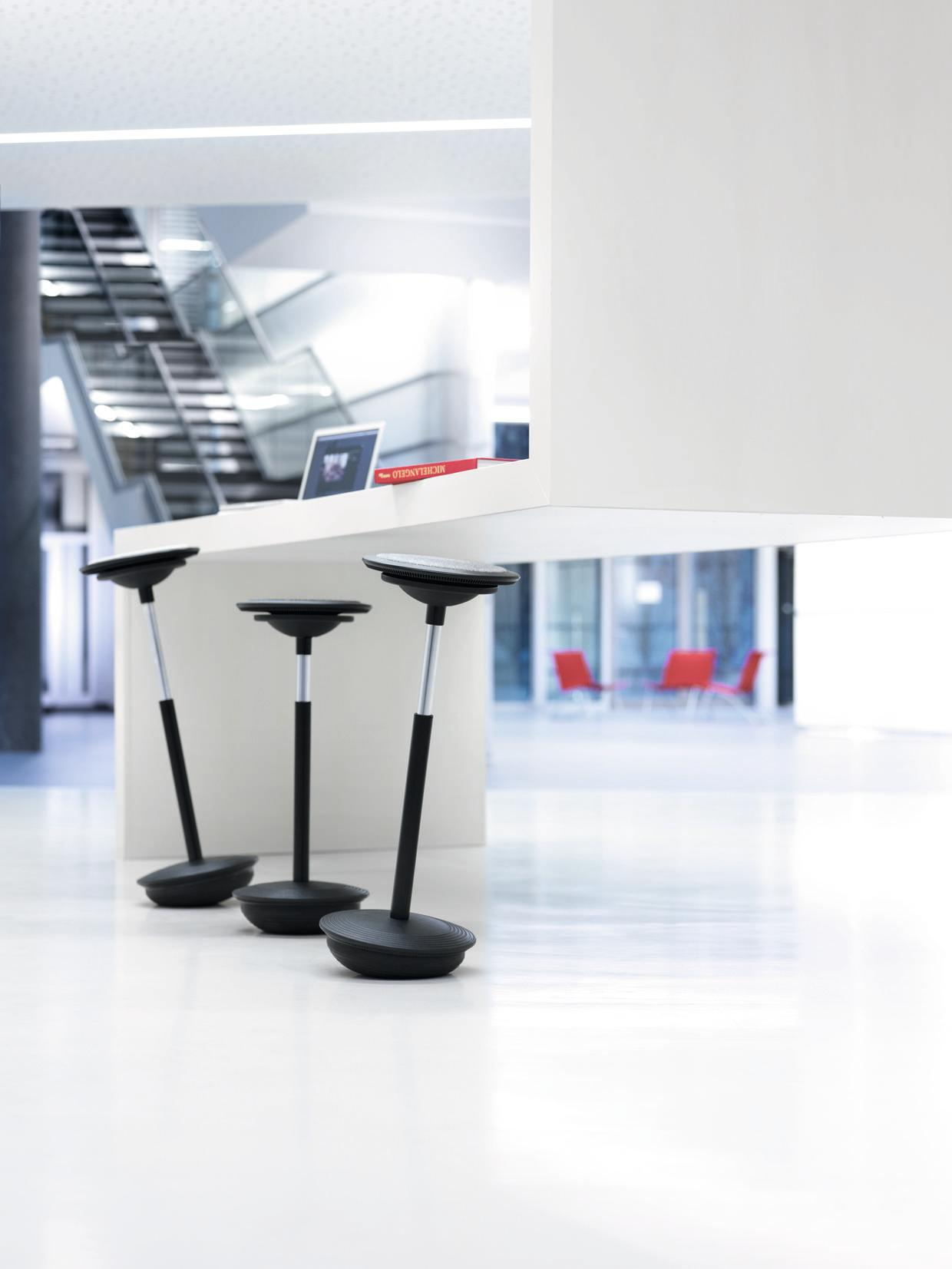 Drei schwarze Wilkhahn Stitz Stehhocker im modernen Büro, ergonomische Sitzmöbel für dynamisches Sitzen und Stehen.