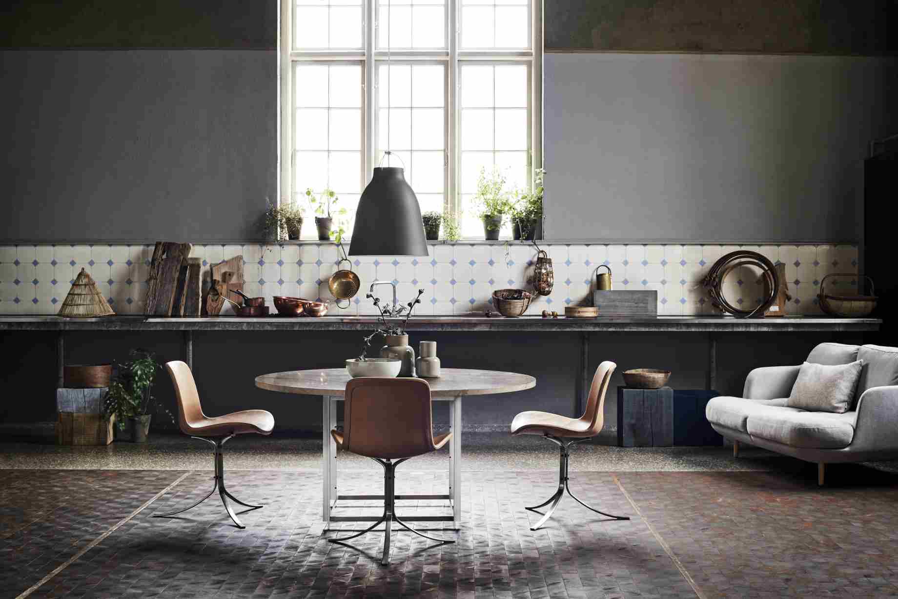 PK54 Esstisch von Fritz Hansen, runder Holztisch mit Stahlgestell und drei Ledersessel in modernem Interieur.
