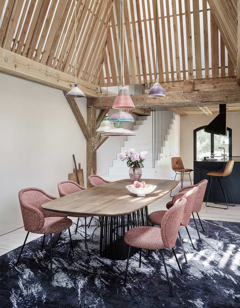 Esszimmer mit Holztisch, sechs Ona Stühlen von Freifrau Manufaktur und bunten Lampen.
