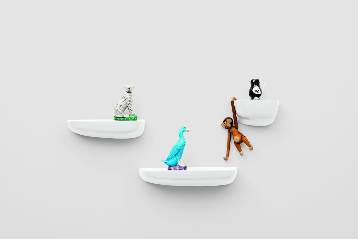Weiße Vitra Corniches Wandboards in verschiedenen Höhen mit Deko-Objekten an einer Wand.