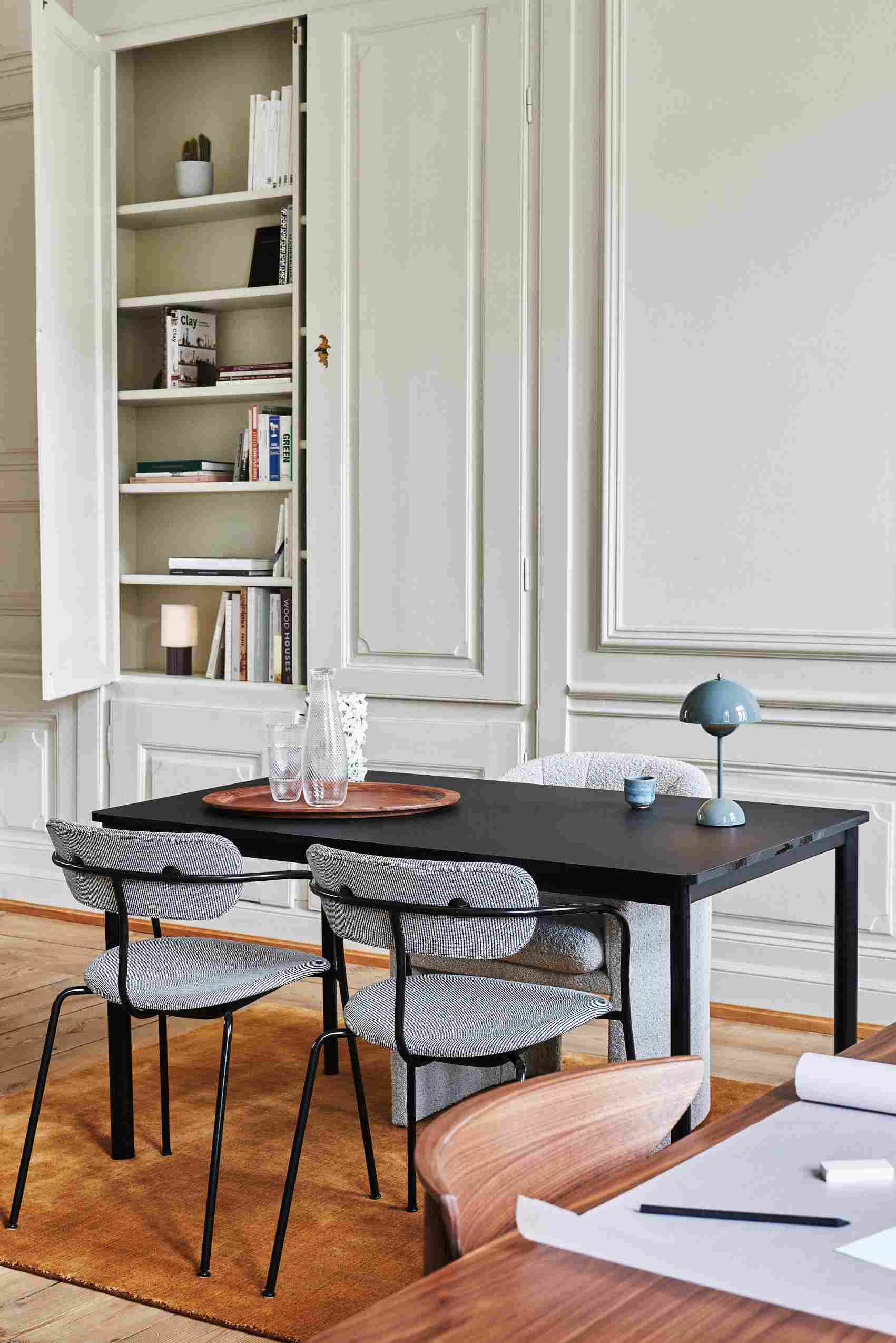 AndTradition Drip Table HW58 Esstisch mit Stühlen und Lampe in einem stilvollen Wohnzimmer.