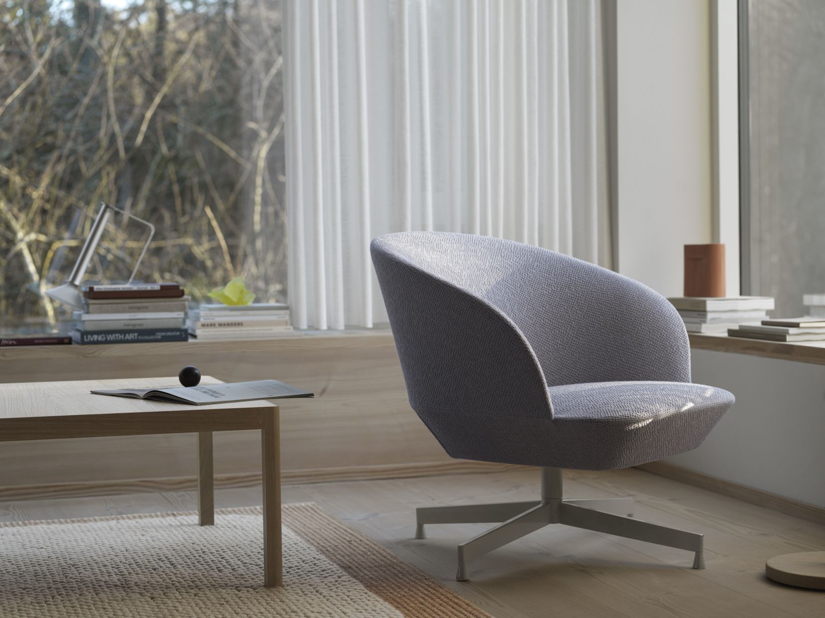 Grauer Oslo Sessel von Muuto mit Drehfuß in modernem Wohnzimmer Ambiente.