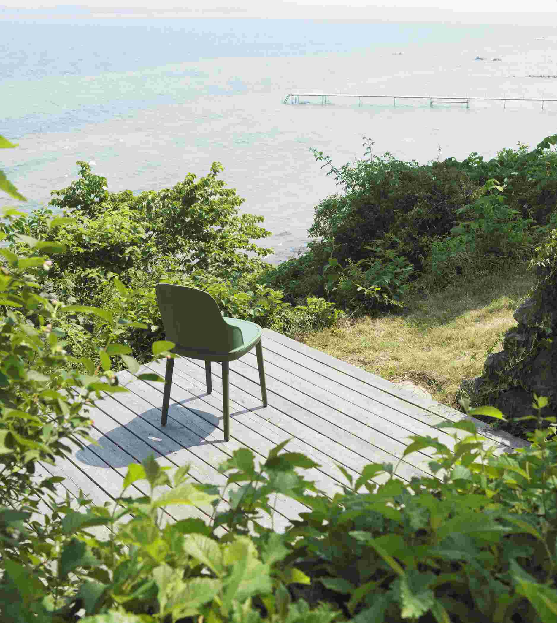 Allez Chair von Normann Copenhagen in Olivgrün auf Holzterrasse mit Meerblick, Gartenstuhl für den Außenbereich.