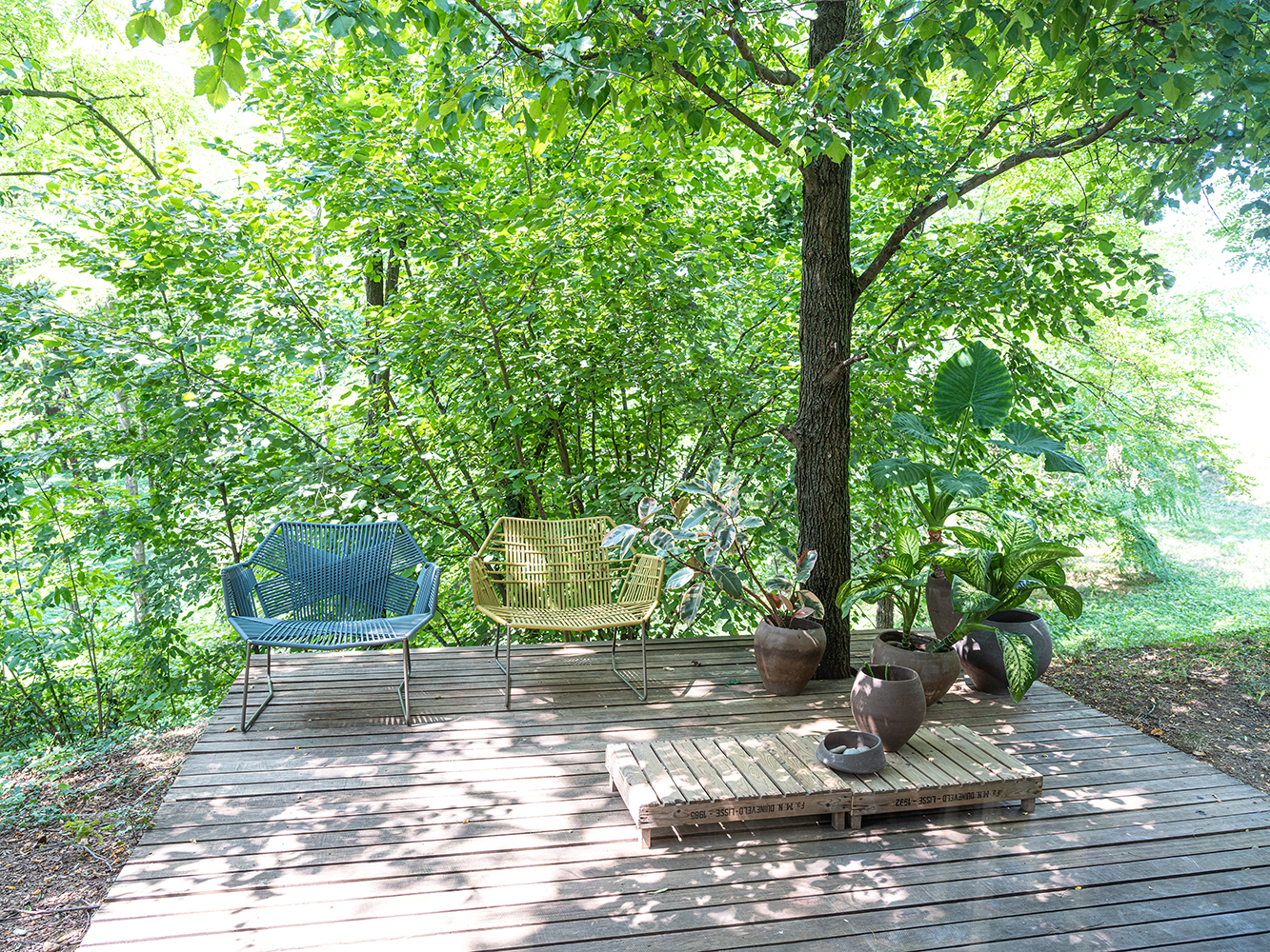 Tropicalia Lounge Sessel von Moroso im Outdoor-Bereich auf Holzterrasse mit grüner Umgebung.